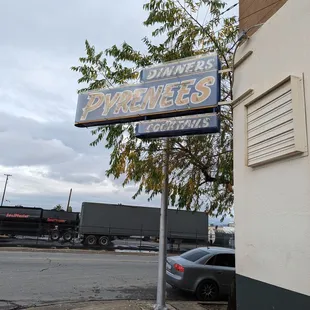 a sign for a restaurant on the corner of a street