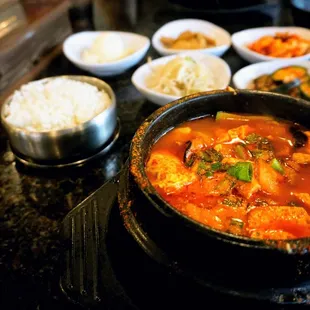 Sundubu: spicy beef broth w/ silk tofu, vegetable, egg, choice of pork, seafood, veggie, or combo (+$1). Includes banchan and rice ($16.99).