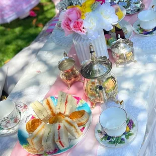 a table with tea and sandwiches