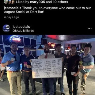 a group of people holding a check