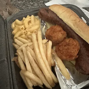 Big sausage sandwich with fries and Mac &amp; cheese