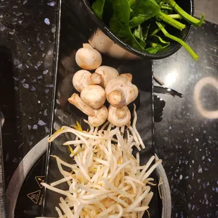 a bowl of mushrooms and spinach on a table