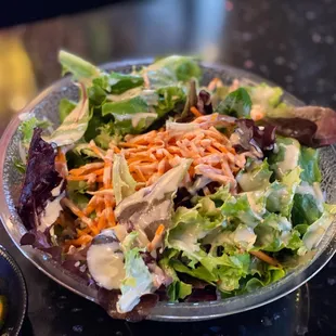 a plate of salad and a bowl of carrots