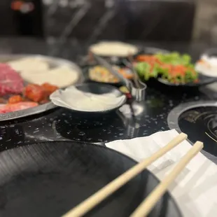 a variety of food on a table with chopsticks