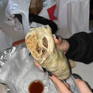 a person holding a burrito
