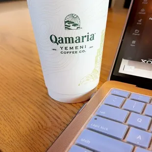 a cup of coffee next to a laptop