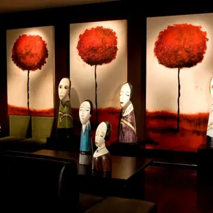 a row of mannequins in front of paintings