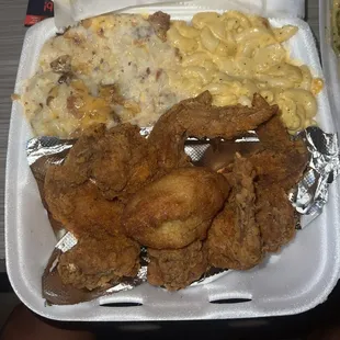 fried chicken, macaroni and cheese and macaroni in a styrofoam container