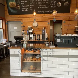 a coffee shop counter with a menu on the wall