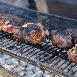 steaks cooking on a grill
