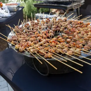 a bowl of skewered food