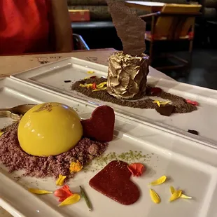 Lychee mousse with mango glazing and guava filling over passionfruit sponge cake and edible chocolate spoon