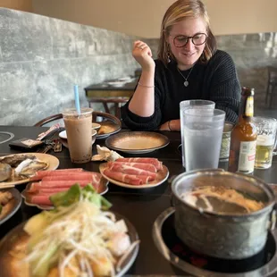a woman sitting at a table full of food