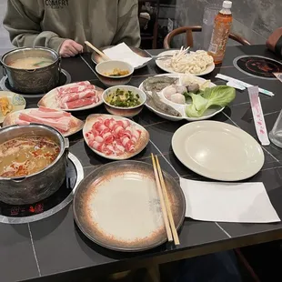 Closest meat is the fatty beef then to the left is the pork belly and the furthest is the fatty lamb