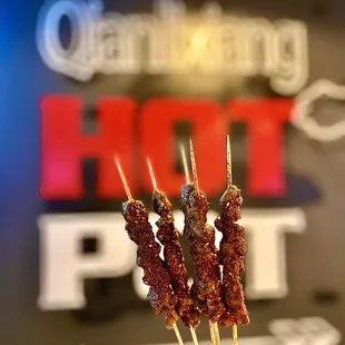 a person holding a skewer of food