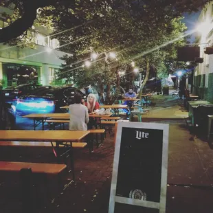 a man sitting at a table outside a restaurant
