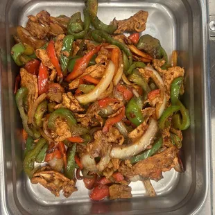 chicken, peppers, onions, and peppers in a serving dish