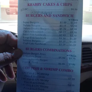 a hand holding a menu