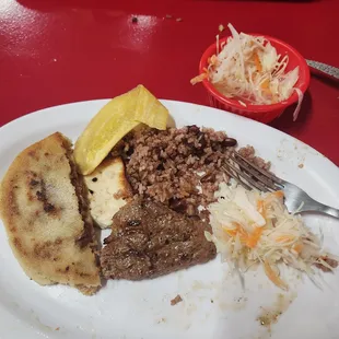 Pupusa, fried cheese, beans &amp; rice, steak, slaw, crispy fried plantain chips.