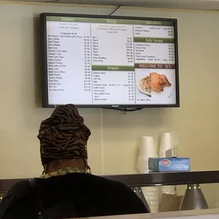 a woman sitting in front of a menu