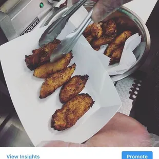 a person holding a tray of fried bananas