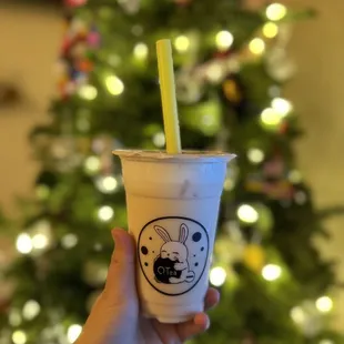 a hand holding a cup of boba