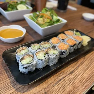 a plate of sushi and a bowl of dipping sauce