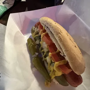 a hot dog with pickles and mustard