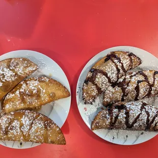 two plates of empanadas on a red table