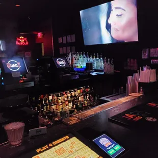 a bar with a large screen in the background