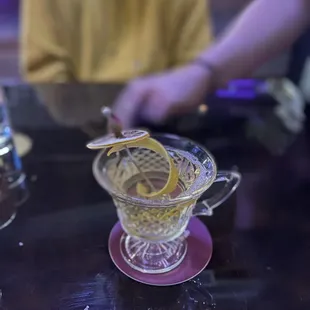a glass teacup with a lemon slice in it