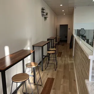 a row of tables and stools in a coffee shop