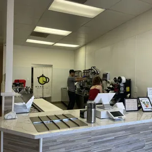 a coffee shop counter with two people working