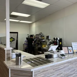 a kitchen with a counter and a man in the background