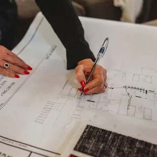 a woman&apos;s hand drawing a floor plan