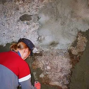 a woman working on a wall