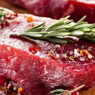 two raw steaks on a cutting board