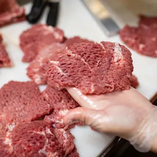 a person holding a piece of meat