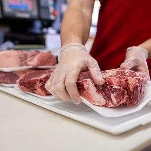 a butcher cutting a piece of meat