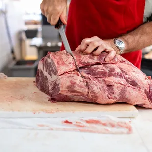 a man cutting a piece of meat