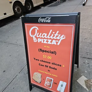 a sign on a sidewalk in a city