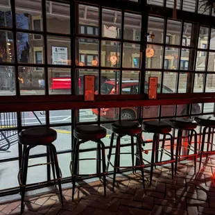 a row of bar stools in front of a window