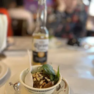 a bowl of food and a bottle of beer