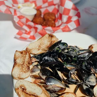 a plate of mussels and bread