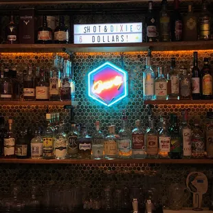 a neon sign and liquor bottles