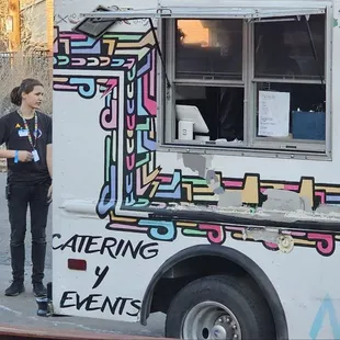 a woman standing in front of a food truck