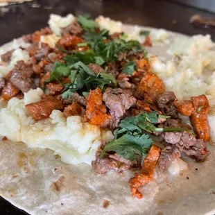 a tortilla with meat and vegetables