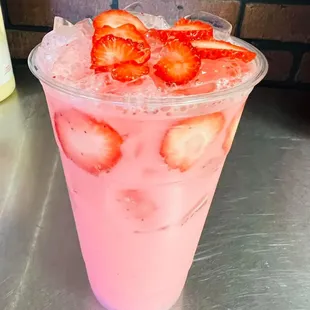 a pink drink with strawberries in it