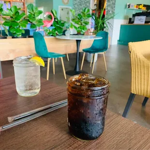 a jar of iced coffee and a glass of water
