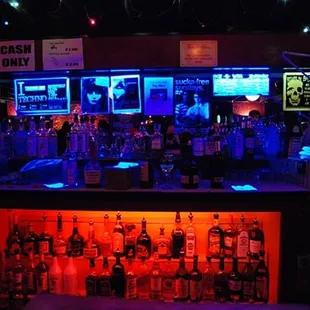 a dimly lit bar with neon lights